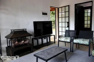a living room with a tv and a table and chairs at Kilmister Cottage in Dullstroom