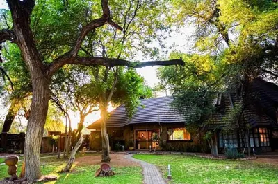 a house with a tree in front of it at Tumuga Game Ranches