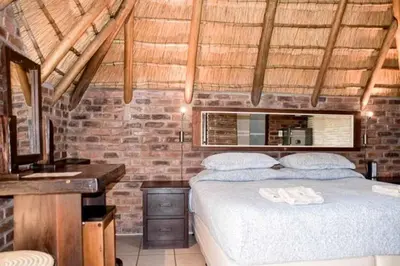 a bedroom with a bed and a brick wall at Tumuga Game Ranches
