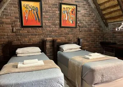 a room with two beds in a brick wall at Tumuga Game Ranches