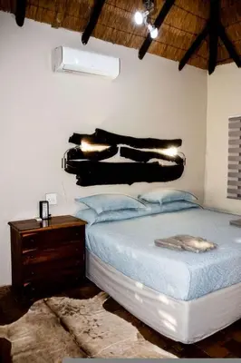 a bedroom with a bed with a dresser and a blackigunigunigun at Tumuga Game Ranches