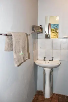 a bathroom with a sink and a mirror and towels at Tumuga Game Ranches