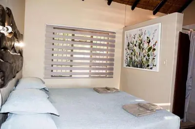 a bedroom with a bed with two pillows and a window at Tumuga Game Ranches