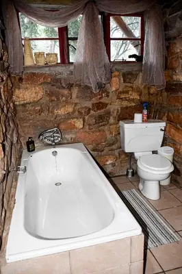 a bathroom with a bath tub and a toilet at Tumuga Game Ranches