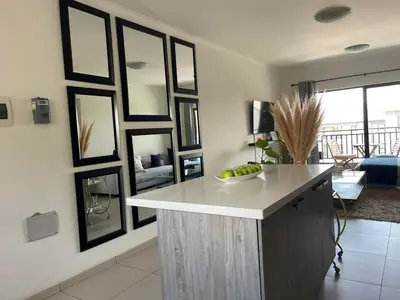 a kitchen with a white counter and black frames on the wall at Modern and Elegant Cozy Living in Midrand