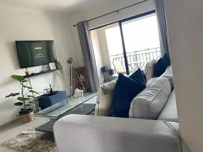 a living room with a couch and a tv at Modern and Elegant Cozy Living in Midrand