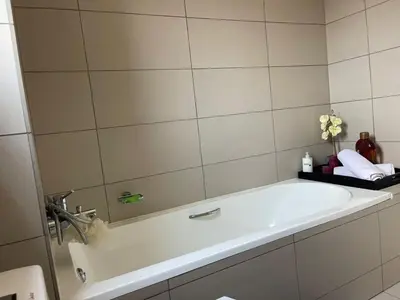 a bathroom with a bath tub with a mirror at Modern and Elegant Cozy Living in Midrand