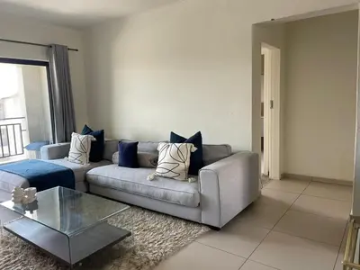 a living room with a couch and a glass table at Modern and Elegant Cozy Living in Midrand