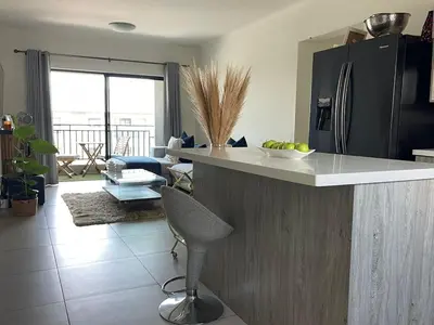 a kitchen with a counter with a chair and a table at Modern and Elegant Cozy Living in Midrand