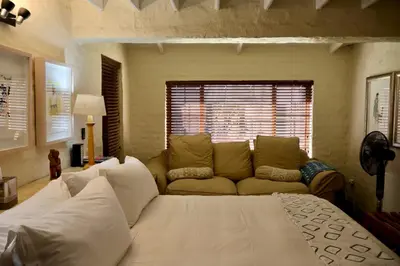 a living room with a white bed and a couch at Delagoa Cottage Dullstroom in Dullstroom
