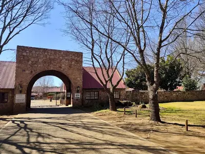 a brick building with an arch in the middle of a road at Delagoa Cottage Dullstroom in Dullstroom