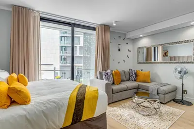 a bedroom with a large bed and a couch at Studio apartment, Ellipse Waterfall in Midrand