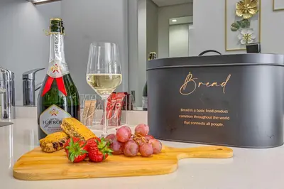 a bottle of wine and a cutting board with fruits and vegetables at Studio apartment, Ellipse Waterfall in Midrand