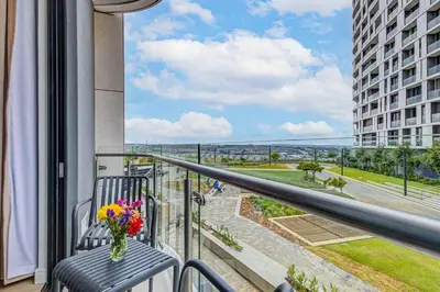 a balcony with a vase of flowers sitting on a chair at Studio apartment, Ellipse Waterfall in Midrand