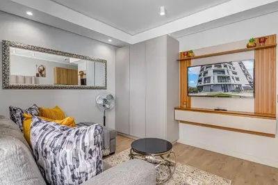 a living room with a couch and a mirror at Studio apartment, Ellipse Waterfall in Midrand