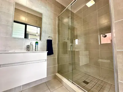 a bathroom with a shower with a glass door at The Blyde - 3 Bedroom Lagoon Facing Luxury Apartment in Pretoria