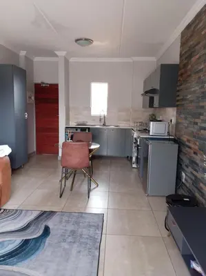 a kitchen with a table and chairs in a room at One-Bedroom Escape in Midrand