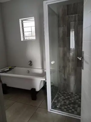 a bathroom with a bath tub and a shower at One-Bedroom Escape in Midrand