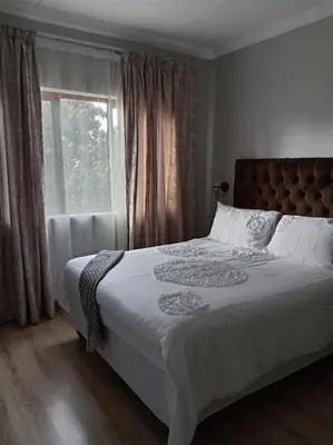 a bedroom with a large bed with a window at One-Bedroom Escape in Midrand