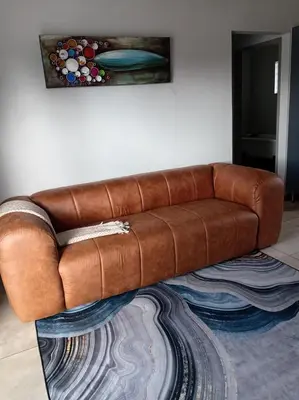 a brown leather couch sitting in a living room at One-Bedroom Escape in Midrand