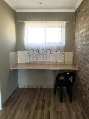 a window with a shelf and a chair in a room at Bredell Motel in Bredell