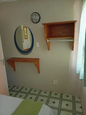 a bathroom with a mirror and a mirror shelf at Manoutsa Holiday Resort in Hoedspruit
