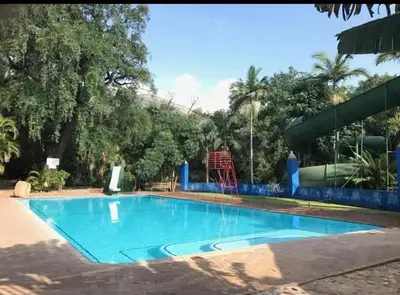 a large blue swimming pool in a park at Manoutsa Holiday Resort in Hoedspruit
