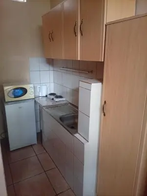 a small kitchen with a sink and a refrigerator at Manoutsa Holiday Resort in Hoedspruit