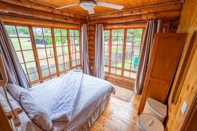 a bedroom with a bed in a log cabin at Little Lions in Dullstroom