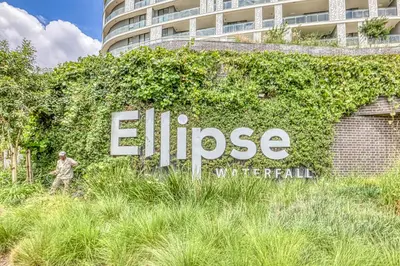 a man standing in front of a sign in front of a building at The Oud at Ellipse Waterfall in Vosburg