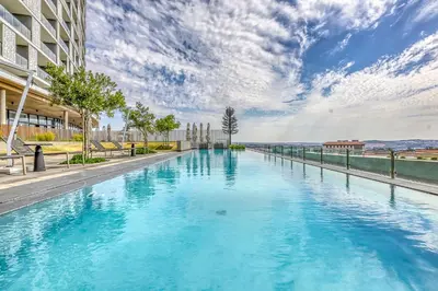 a large pool with blue water in a building at The Oud at Ellipse Waterfall in Vosburg