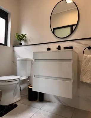 a bathroom with a white toilet and a mirror at The solace in Midrand