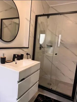 a bathroom with a shower and a sink and a mirror at The solace in Midrand
