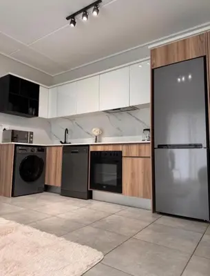 a kitchen with white cabinets and a large appliance at The solace in Midrand