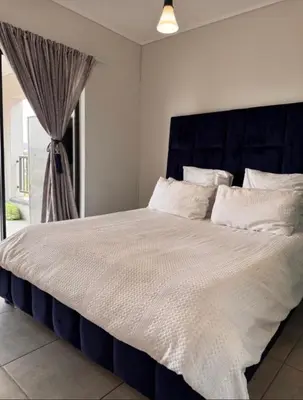 a large bed with a blue headboard in a bedroom at The solace in Midrand
