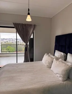 a bedroom with a bed with a large window at The solace in Midrand