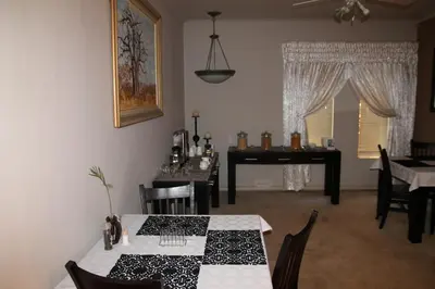 a dining room with a table and a piano at Sekelbos Guesthouse in Pretoria