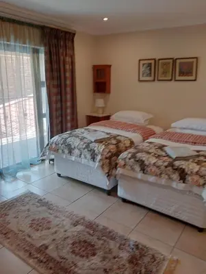a bedroom with two beds and a rug at Bekkersheim in Pretoria