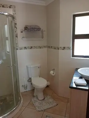 a bathroom with a shower and a toilet and a sink at Bekkersheim in Pretoria