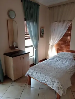 a bedroom with a bed and a window at Bekkersheim in Pretoria
