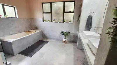a bathroom with a bath tub and two sinks at Stille Uitsig Hazyview in Hazyview