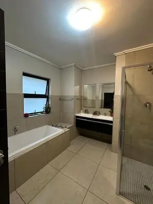 a large bathroom with a tub and a sink at The City Escape in Midrand