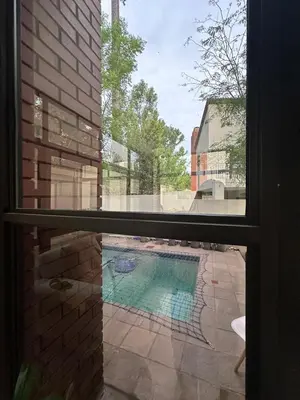 a view of a swimming pool through a window at The City Escape in Midrand