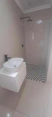 a white bathroom with a sink and a shower at 33 On Driedoring in Kempton Park