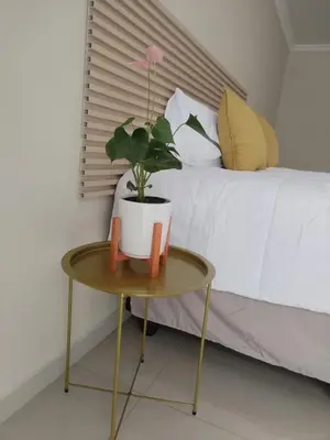 a table with a potted plant on it next to a bed at 33 On Driedoring in Kempton Park