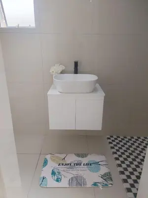 a white bathroom with a sink and a towel on the floor at 33 On Driedoring in Kempton Park