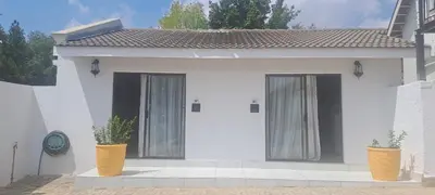 a white house with two vases in front of it at 33 On Driedoring in Kempton Park
