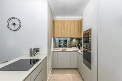 a kitchen with white cabinets and a counter top at RestHaus Suite, Ellipse Waterfall in Midrand