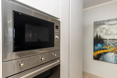 a flat screen tv in a room with a painting at RestHaus Suite, Ellipse Waterfall in Midrand