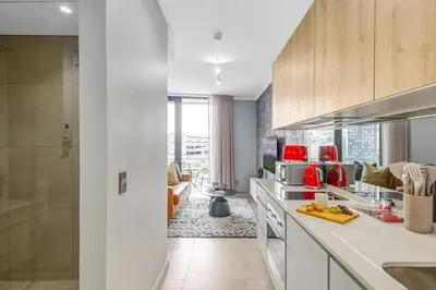 a kitchen with white counters and red appliances at WanderHaus Haven, Ellipse in Midrand
